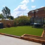 New artificial lawn with surrounding flower beds
