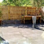Mill hill new porcelain patio and clad raised flower bed and fencing